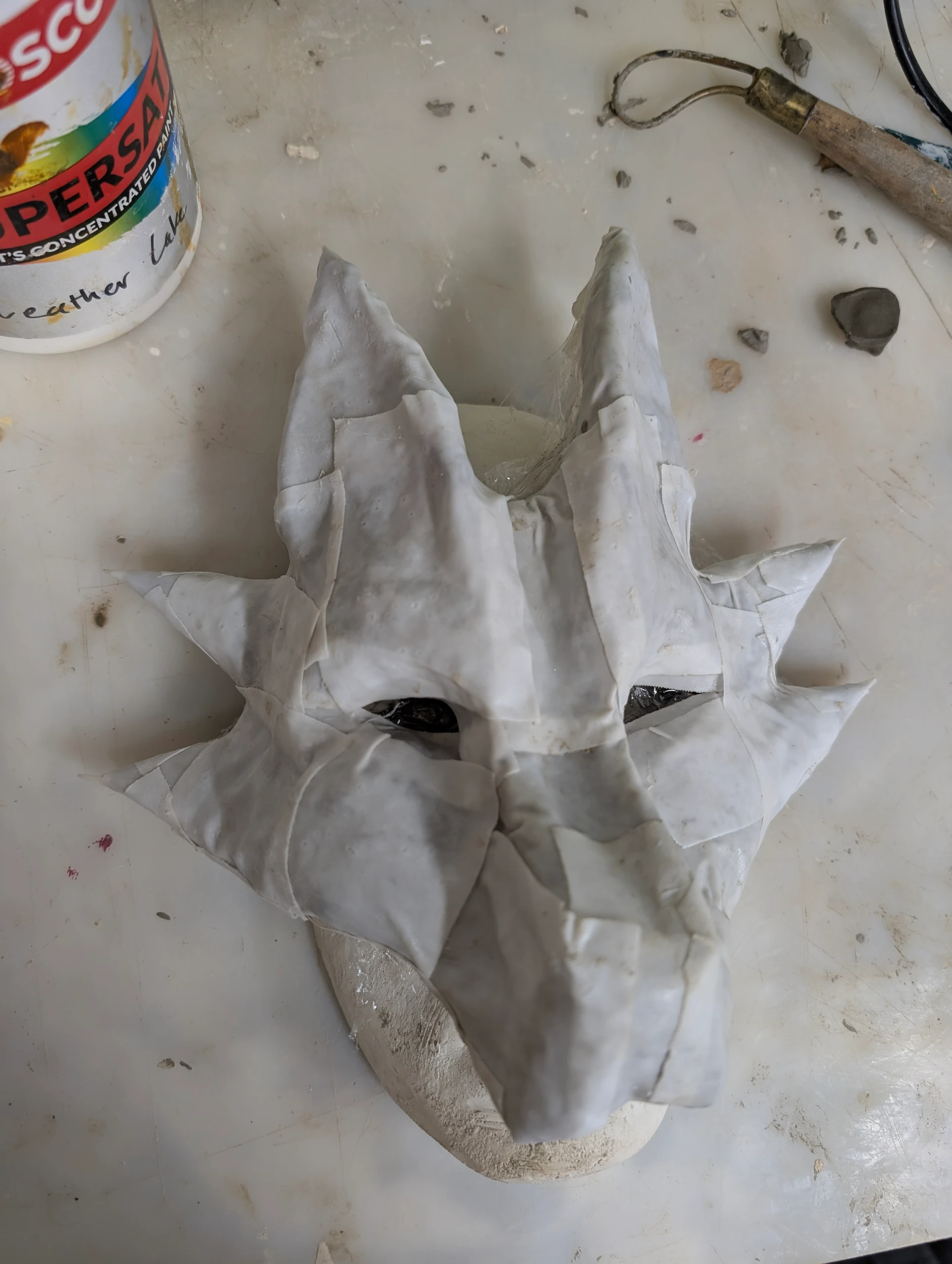 covering the clay model with layers of thermoplastic and papier-mâché
